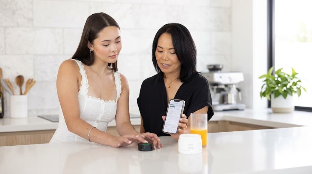 A practitioner and client reviewing a Prysm iO wellness score together on the connected app